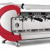 A closeup front/side view of the 3 group Aurelia Wave T3 in red, with Volumetric dosing, and tall brew groups.